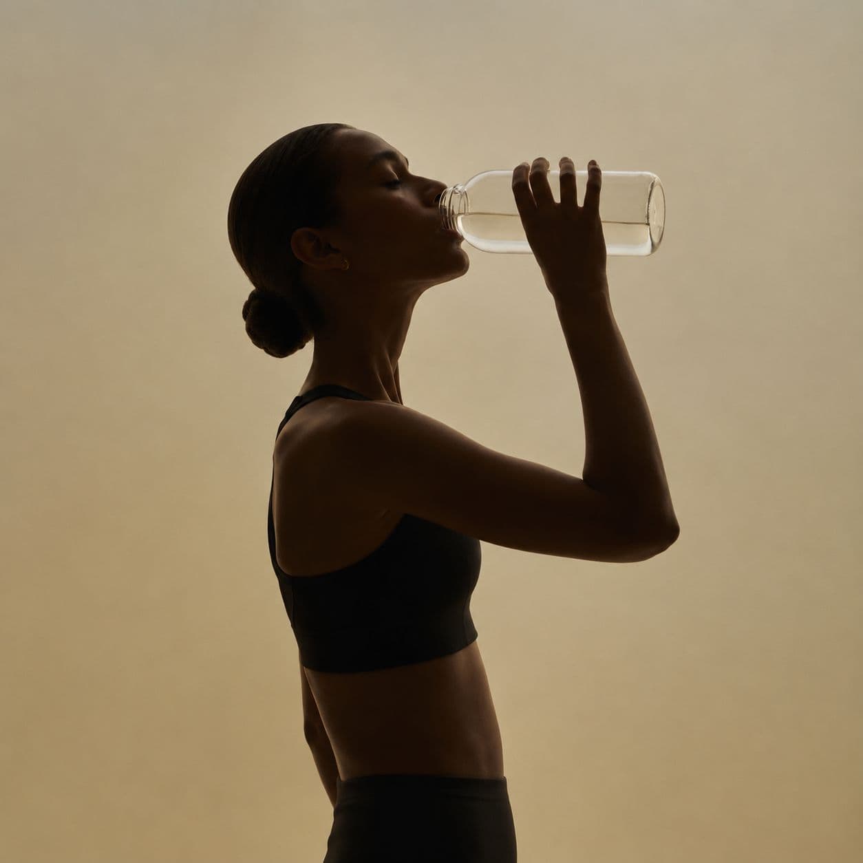 A woman drinking water in warm side light